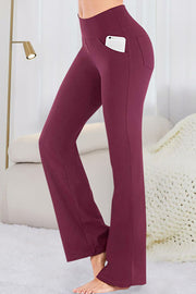 Burgundy flare-leg performance trousers with side pockets holding a smartphone.
