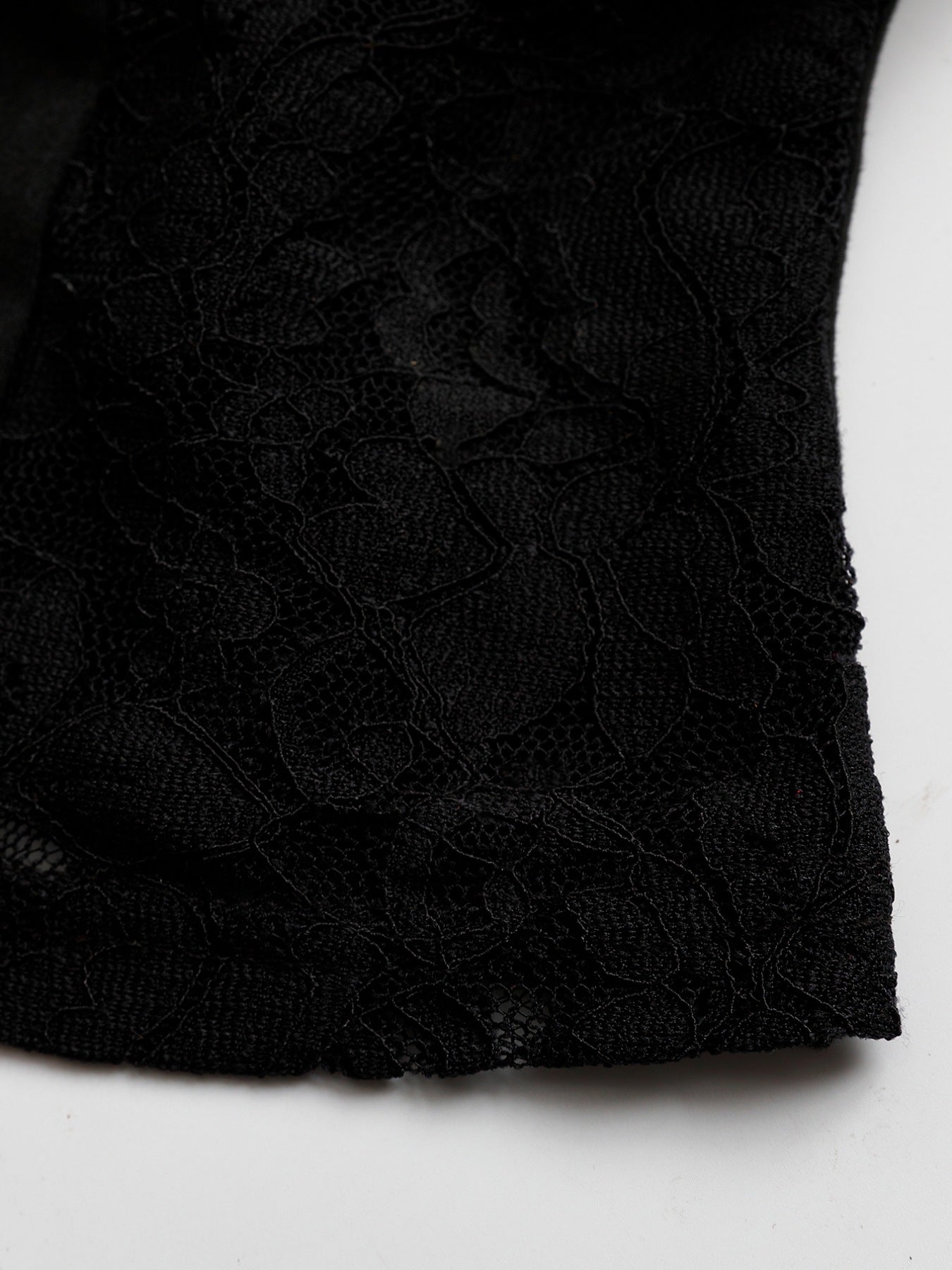 Black lace halter neck cami top with a floral pattern detail.