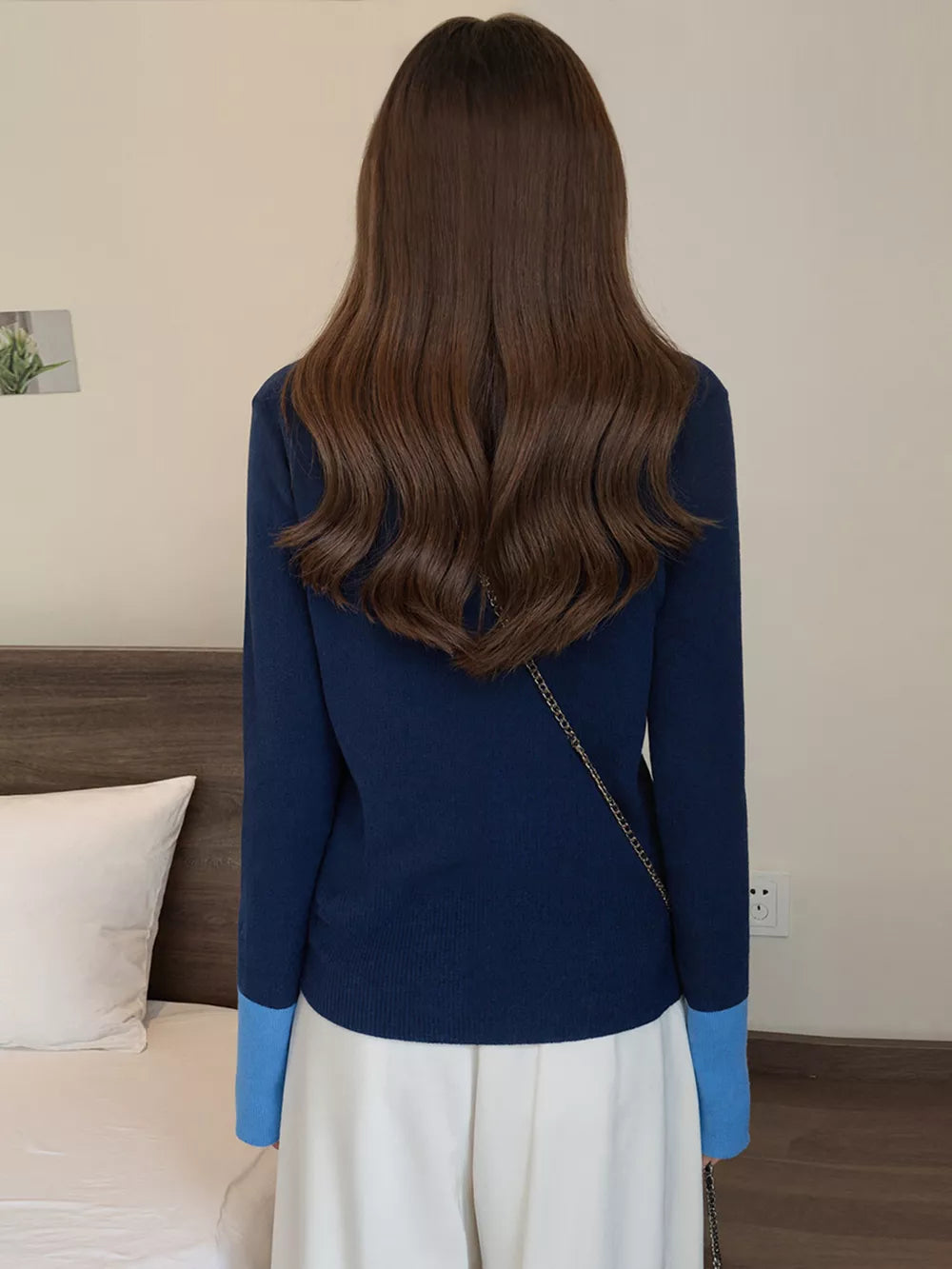 Navy ribbed cardigan with contrast sky blue cuffs and a gold chain strap detail.