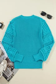 Turquoise knit sweater with textured cutout sleeves and crew neck.