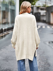 Cream open-stitch waffle knit duster cardigan with side slits and balloon sleeves.