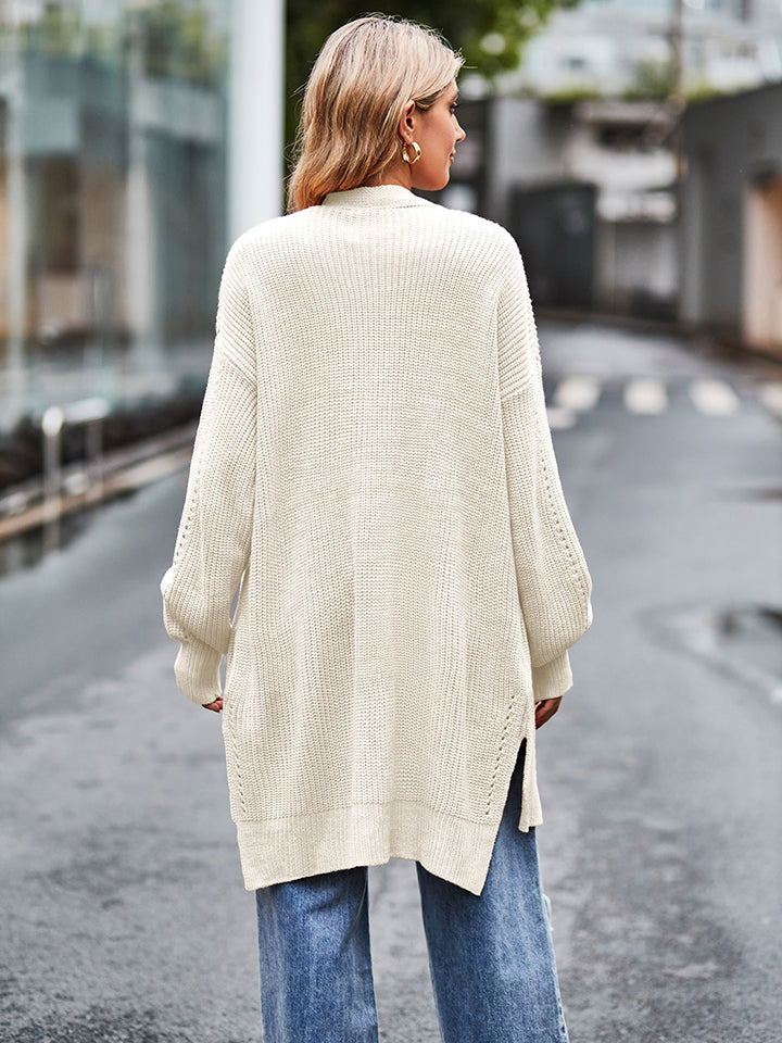 Cream open-stitch waffle knit duster cardigan with side slits and balloon sleeves.