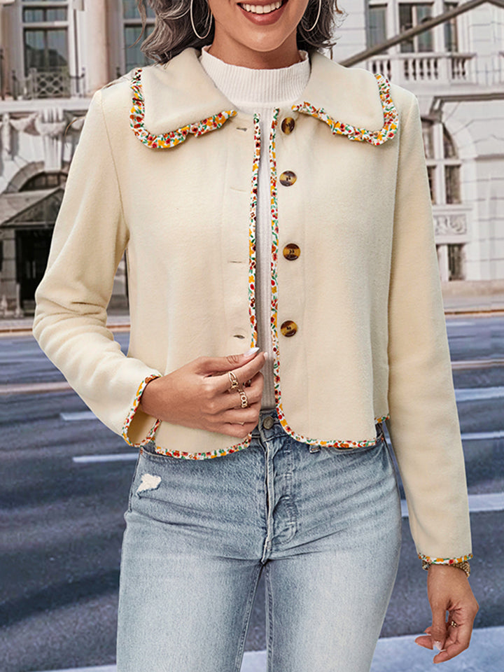 Cream bolero jacket with floral trim and scalloped collar.