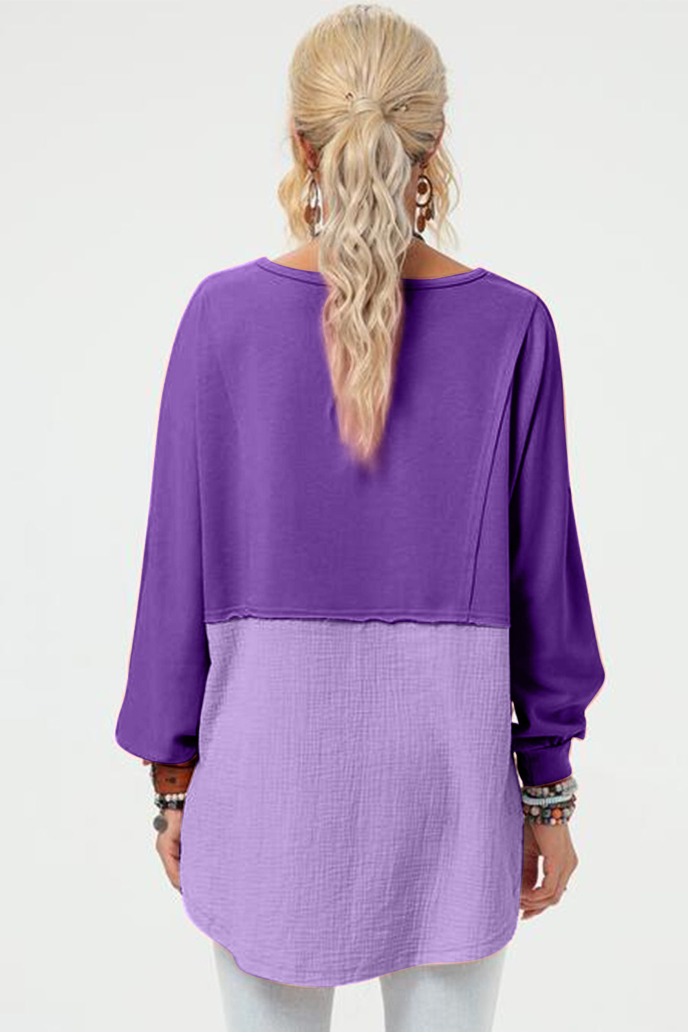 Purple split-panel sweatshirt with asymmetric hemline and textured lower panel.