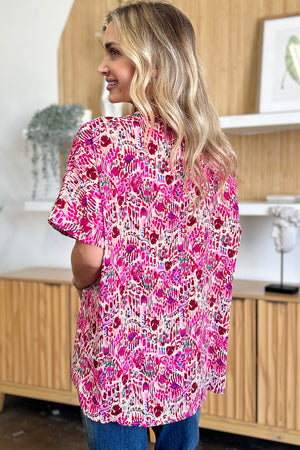 Pink floral ikat relaxed v-neck blouse with short sleeves.