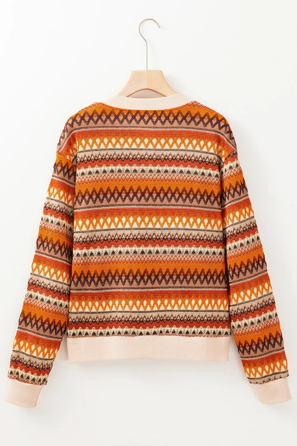Geometric knit bomber jacket in orange with a zig-zag pattern and ribbed cuffs.