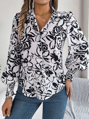 Floral print blouse with shirred cuffs and button front, white with black floral pattern.
