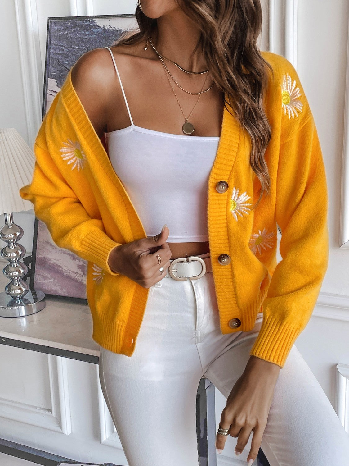 Gold button-down cardigan with daisy embroidery and ribbed cuffs.