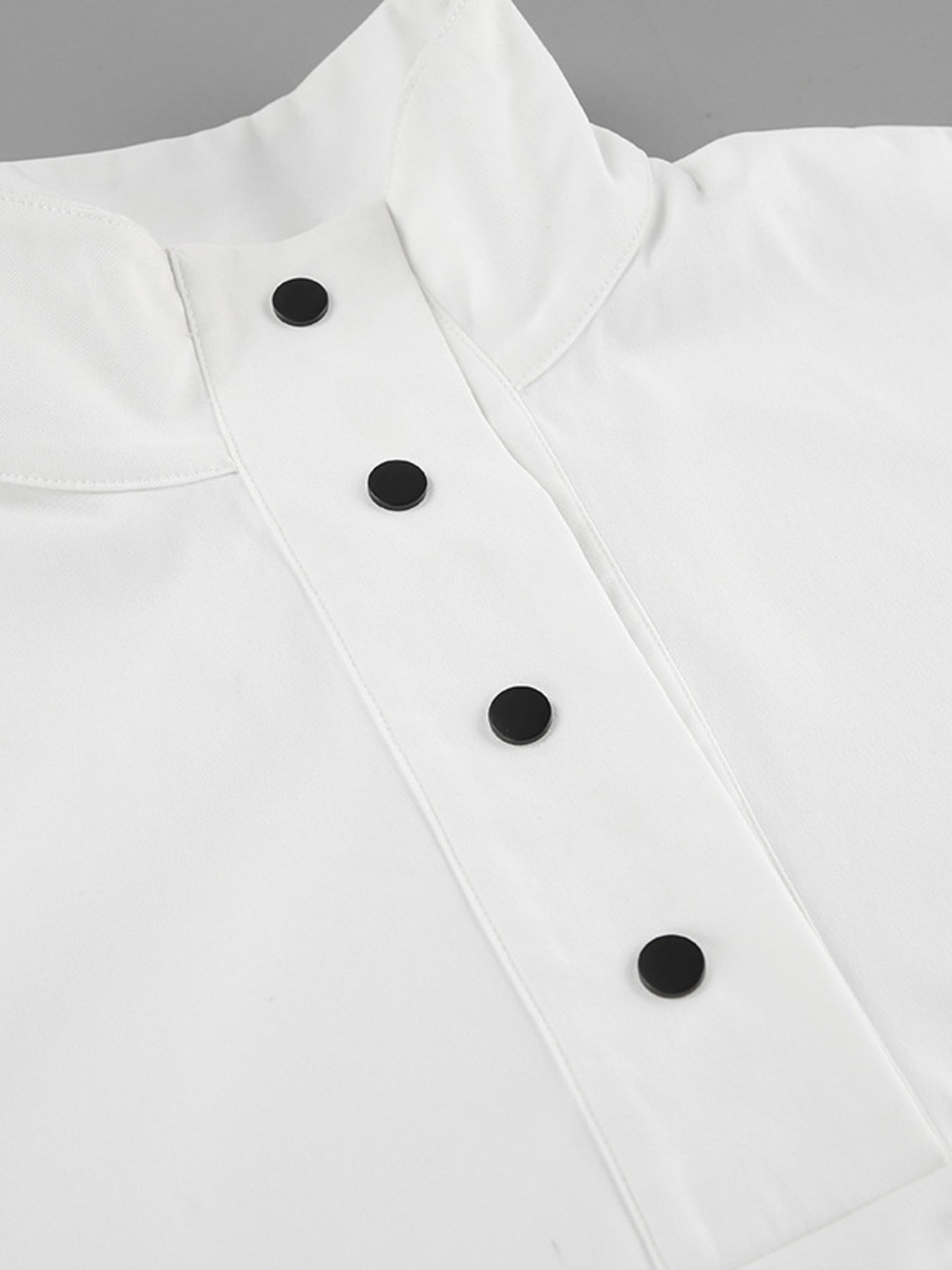 White two-piece set with snap button details and a high neckline.