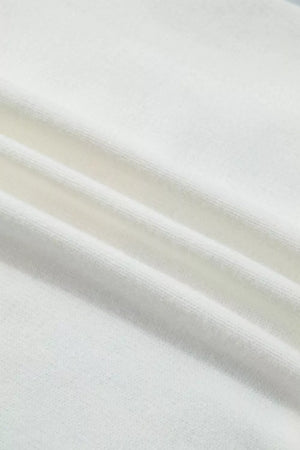 White knit sweater vest fabric detail showing ribbed texture and soft material.