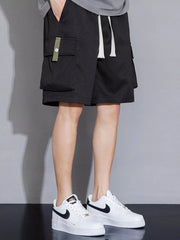 Black cargo shorts with drawstring waist and olive green pocket detail.