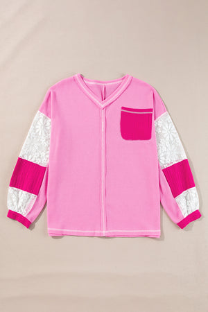 Fuchsia pink waffle knit top with lace paneled sleeves and a chest pocket.