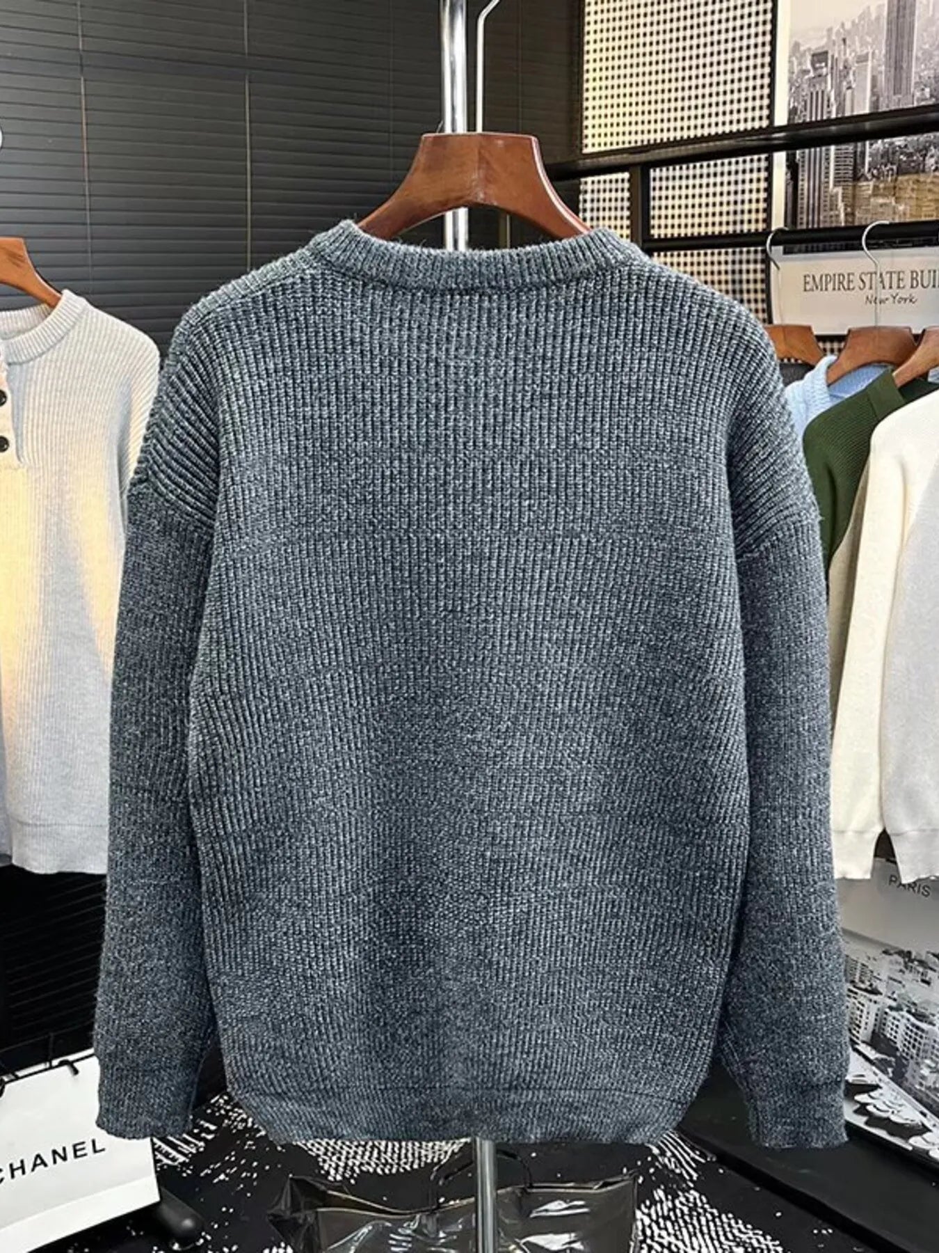 Plus-size gray ribbed knit sweater with button detail on the neckline.