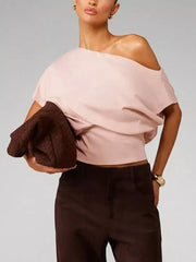 Pink asymmetrical crop t-shirt with draped fit and off-the-shoulder neckline.