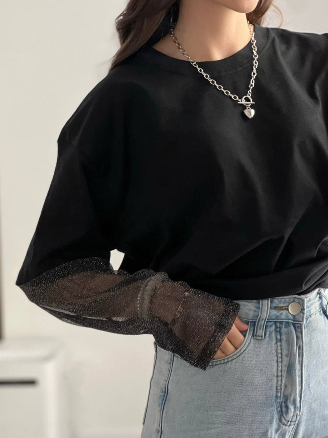 Black oversized tee with sheer sparkly sleeves and a crew neck.