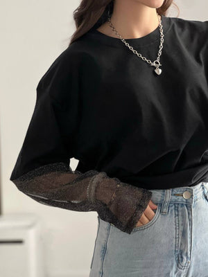 Black oversized tee with sheer sparkly sleeves and a crew neck.