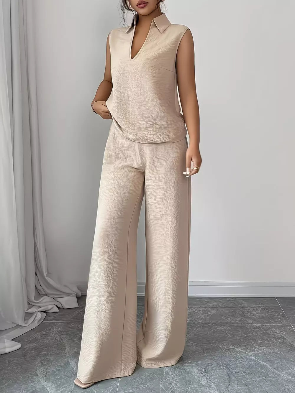Beige sleeveless collared top and wide-leg pants set with textured fabric.
