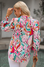 Women's abstract print blouse with gathered cuffs and a collared neckline.