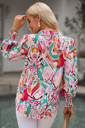 Women's abstract print blouse with gathered cuffs and a collared neckline.