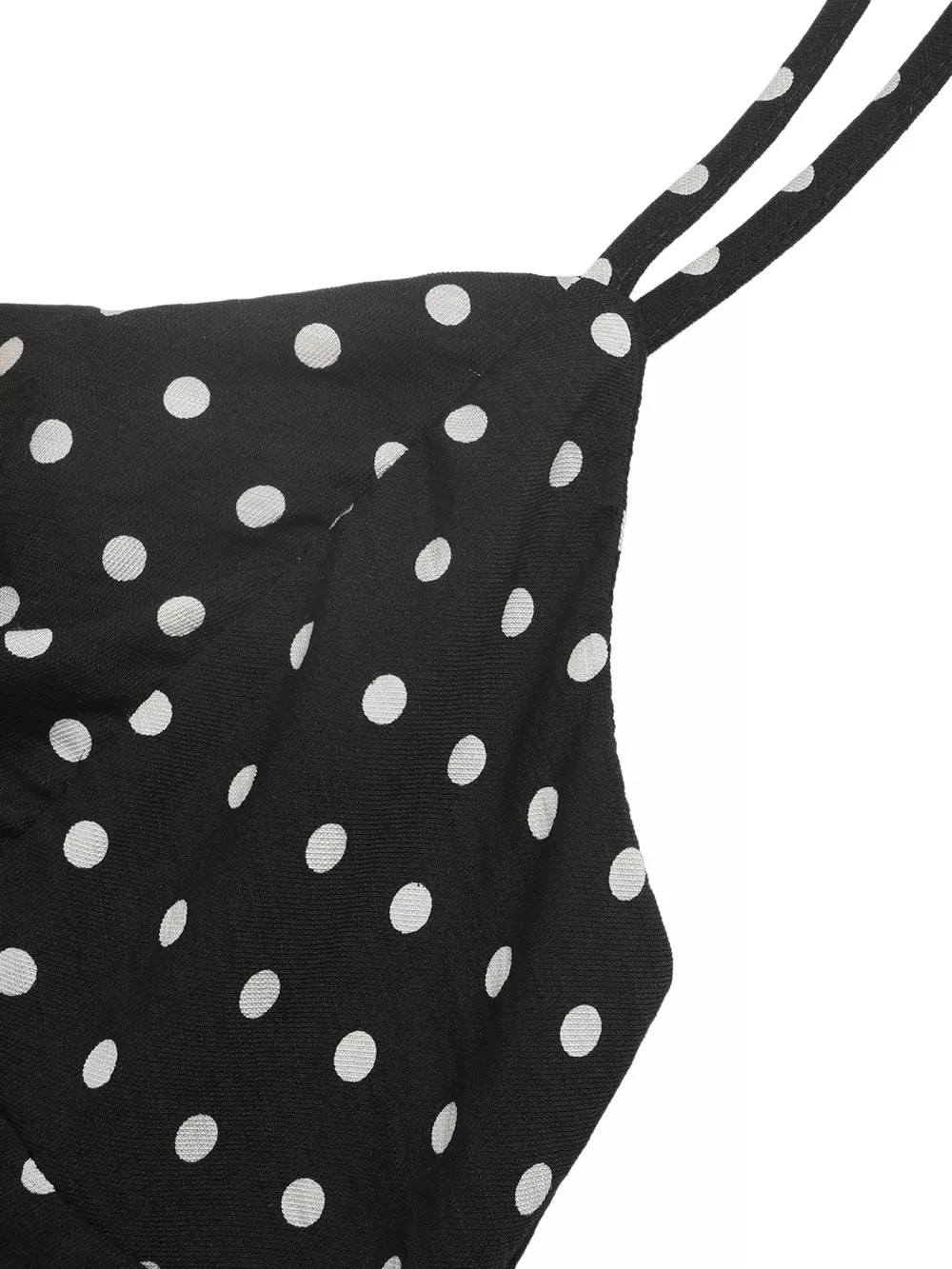 Black polka dot dress with thin spaghetti straps and ruffled hem detail.