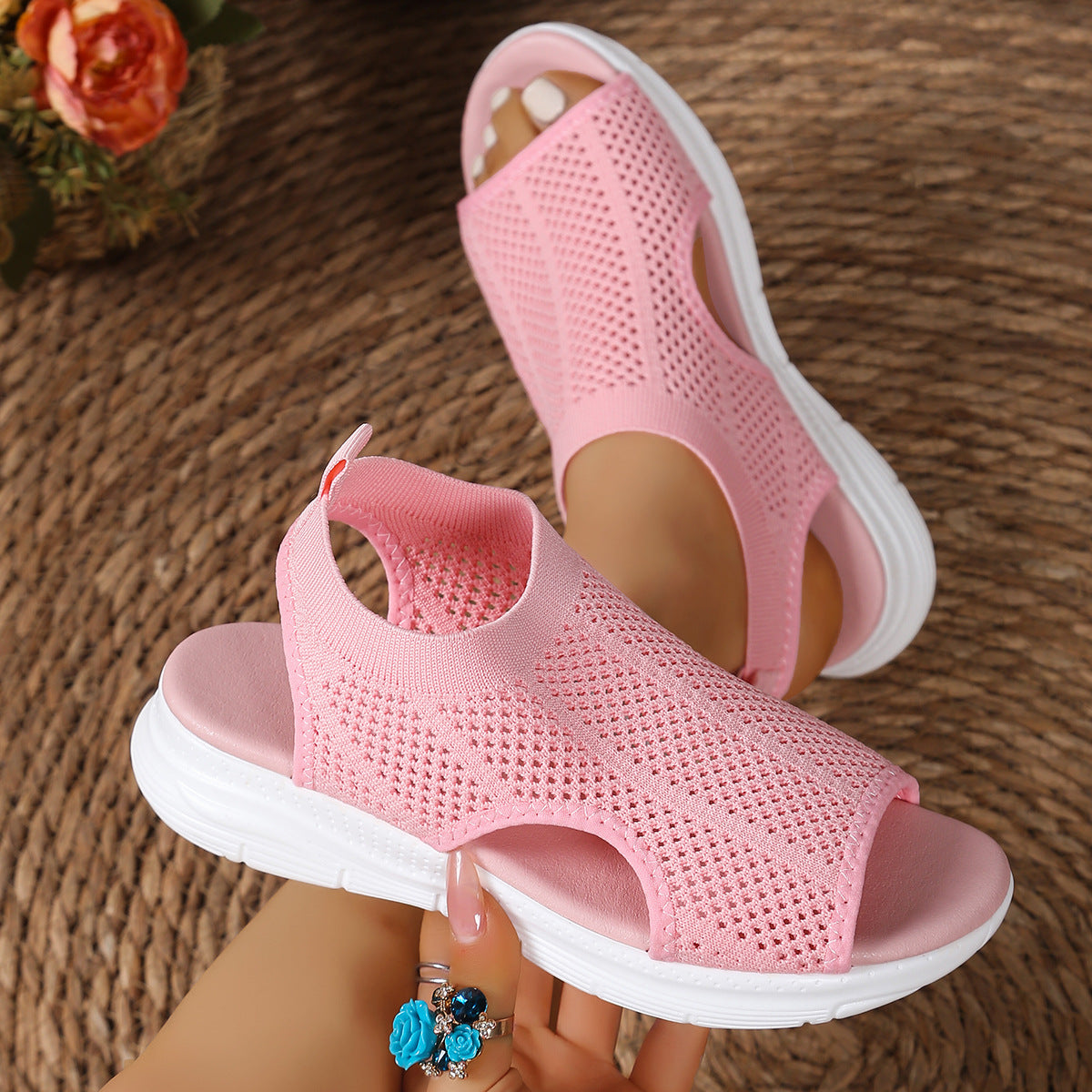 Pink mesh open-toe sandals with a chunky white sole and breathable knit upper.