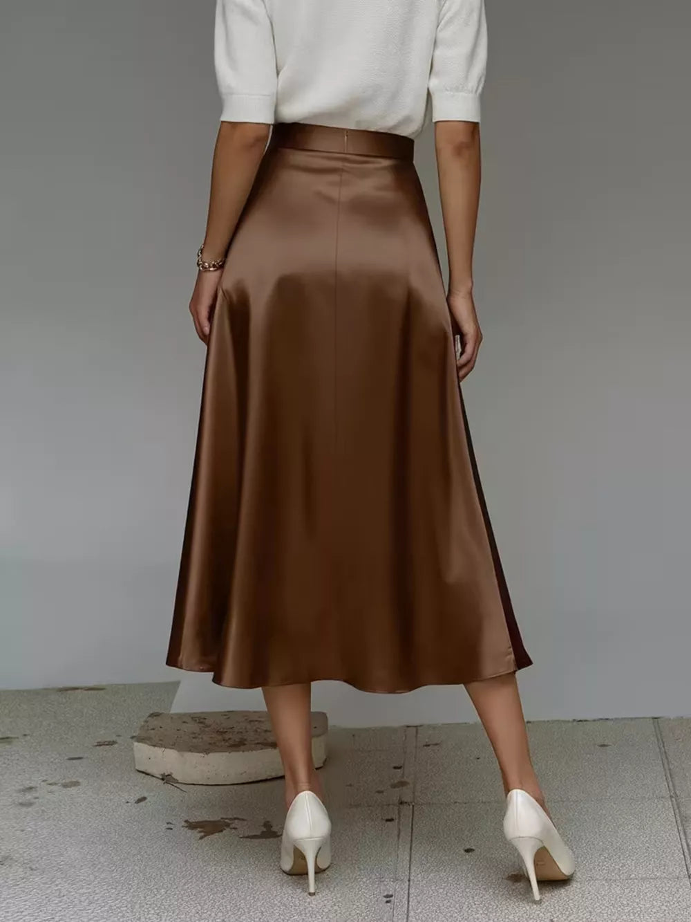 Elegant A-line satin skirt in dark brown with a flowing silhouette.
