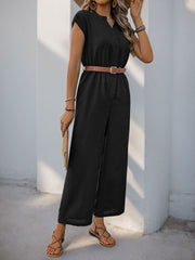 Black cap-sleeve wide-leg jumpsuit with a V-neck and belted waist, styled with sandals.