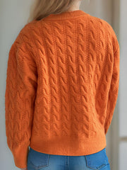 Orange cable knit cardigan with puff sleeves and buttoned front.