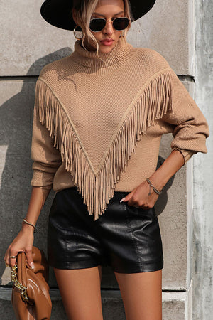 Beige turtleneck sweater with chevron fringe detail and long sleeves.