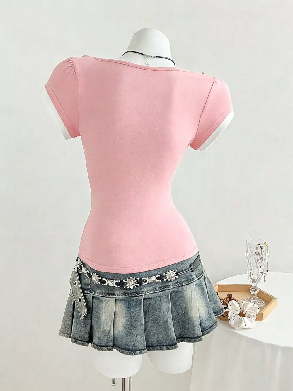 Pink maternity t-shirt with short sleeves, white trim, and a bow detail on the shoulder.