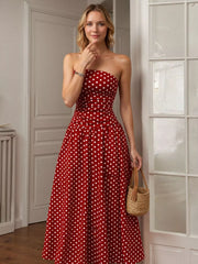 Red polka dot strapless maxi gown with a cinched waist and full skirt.