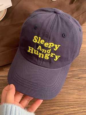 Navy blue cotton baseball cap with yellow embroidered Sleepy And Hungry text