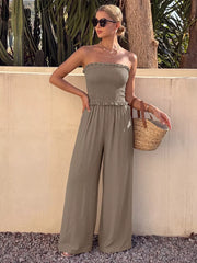 Smocked strapless wide-leg romper in olive with frill detail and flowy pants.