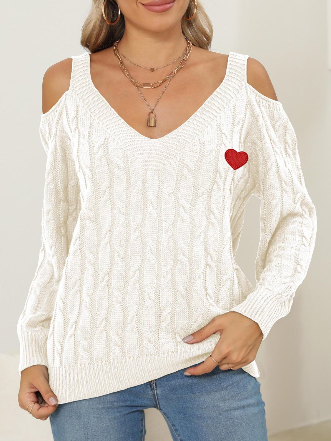 White open shoulder cable knit sweater with red heart detail and v-neck