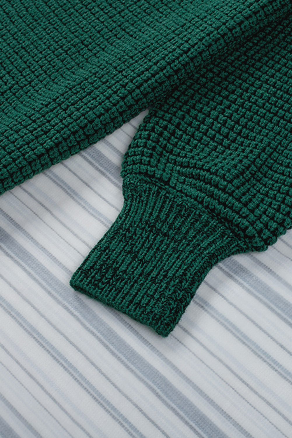 Textured green acrylic cardigan with puff sleeves and ribbed cuffs.