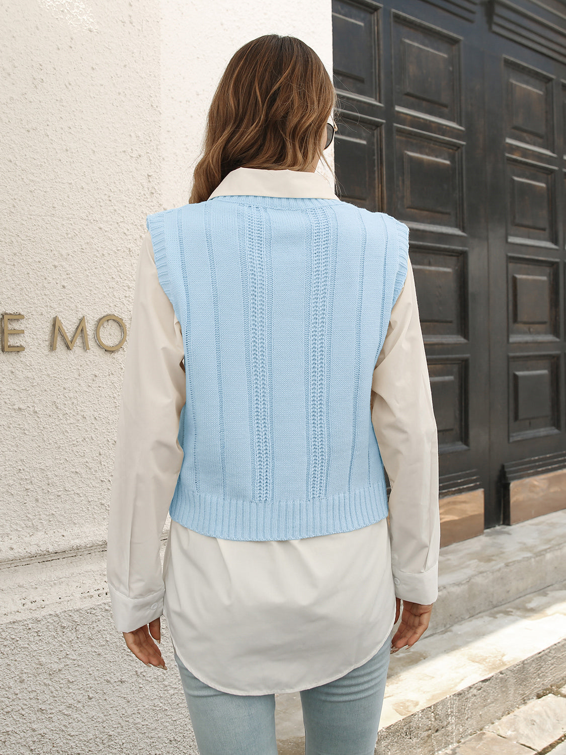Pastel blue acrylic cable knit crop vest sweater with ribbed trim and vertical stitch detail.