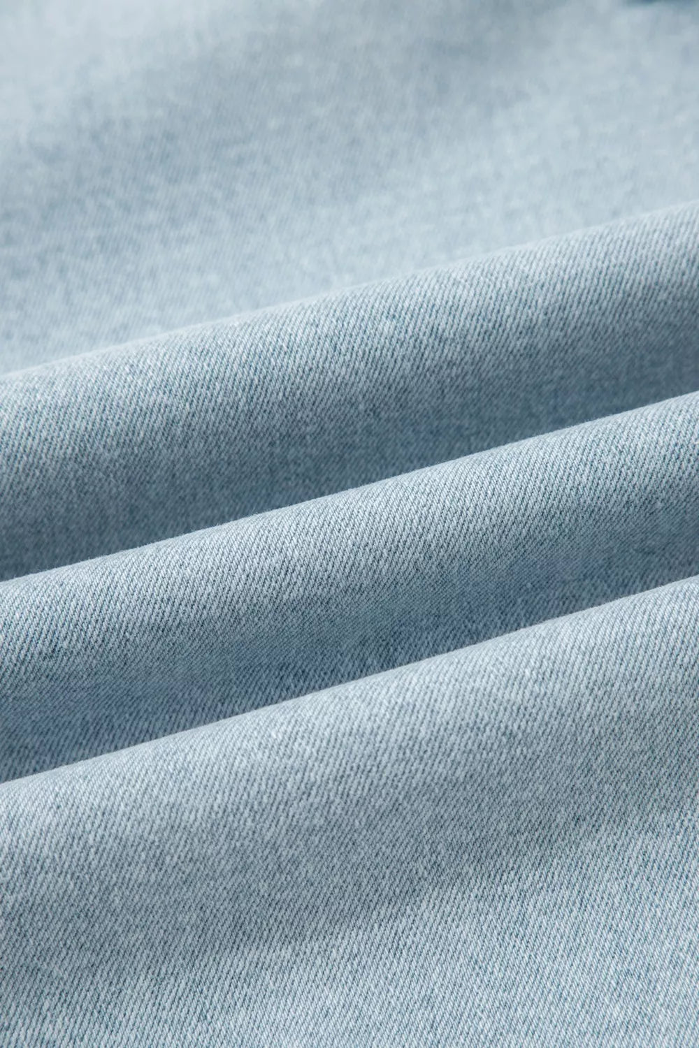 Light wash denim jeans with a textured weave and soft folds.