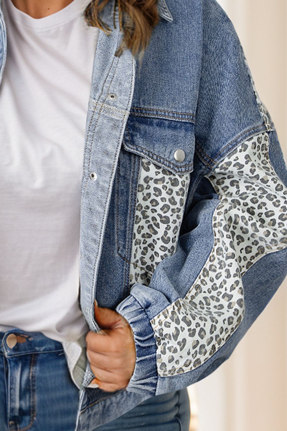 Denim jacket with leopard print panels and elastic cuffs.