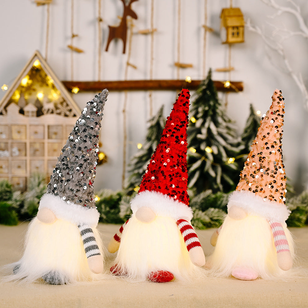 Light-Up Sequin Gnome Trio in dark gray, red, and blush pink with fuzzy beards and striped arms.