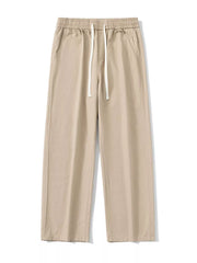 Khaki relaxed fit drawstring pants with elastic waist and white drawcords.