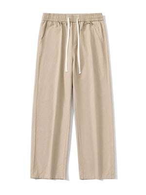 Khaki relaxed fit drawstring pants with elastic waist and white drawcords.