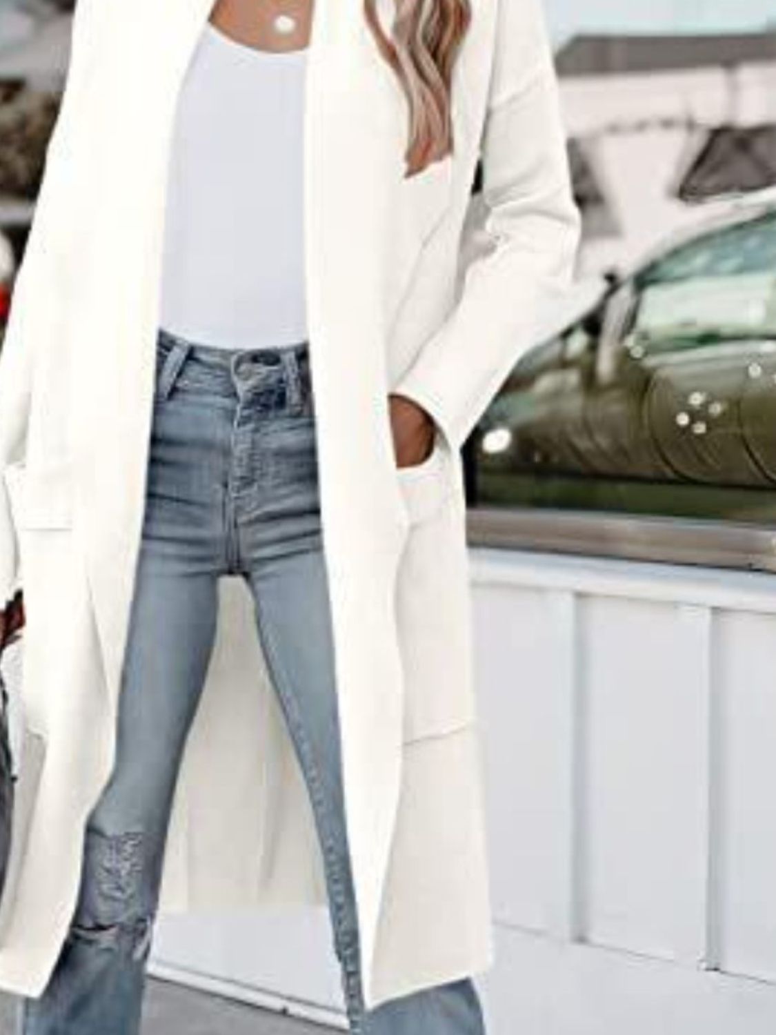 White open-front duster cardigan with pockets, styled with jeans.