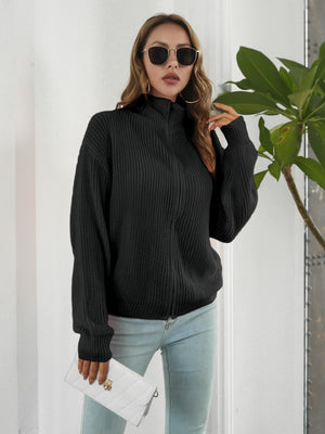 Black ribbed knit zip-up sweater with mock neck and long sleeves.