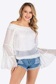 White dotted swiss off-shoulder blouse with ruffle bell sleeves and smocked neckline.