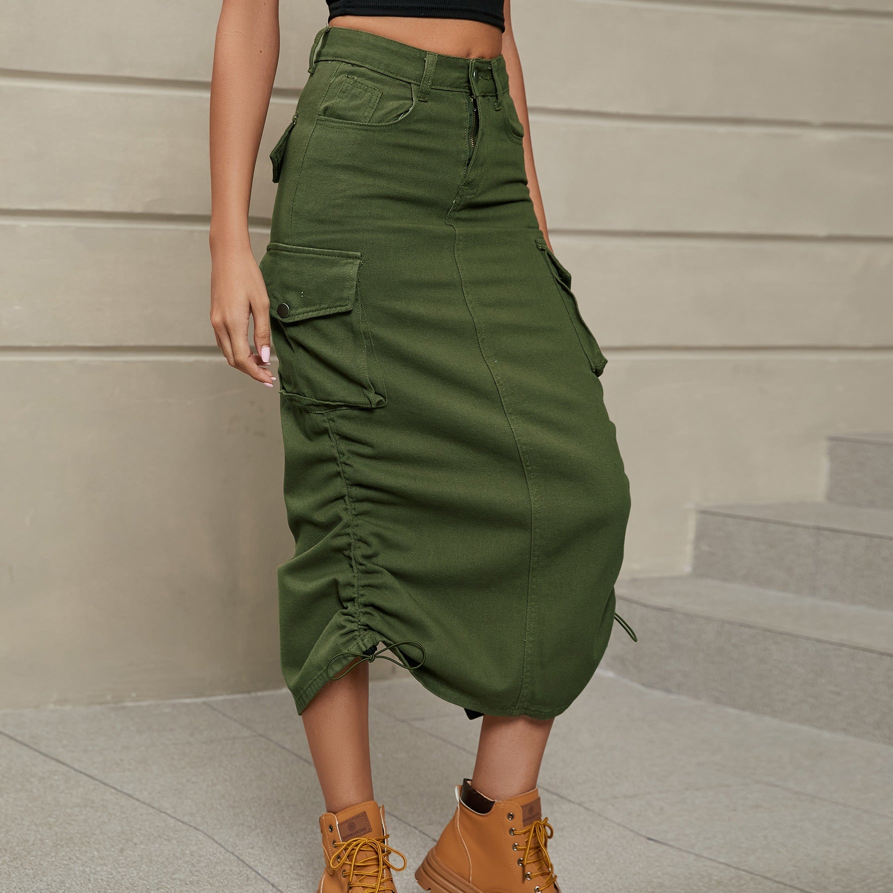 Army green cargo denim midi skirt with adjustable ruching detail and button flap pockets.