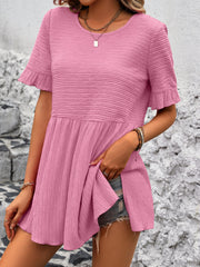 Blush pink textured babydoll blouse with flutter sleeves and a tiered silhouette.