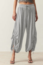 Gray gathered ankle-tie balloon trousers with drawstring waist and ruched detailing.