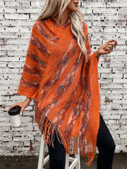 Textured knit hooded fringed cape in terracotta with colorful accents and fringe detail.
