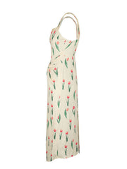 Cream midi dress with tulip print, twist front, and thin straps.
