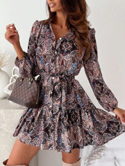 Button-down mini dress with a brown paisley print, tie waist, and tiered skirt.